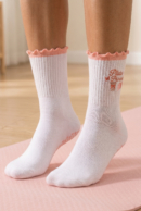 kobieta nosząca białe skarpetki Pilates Princess na różowej macie do ćwiczeń