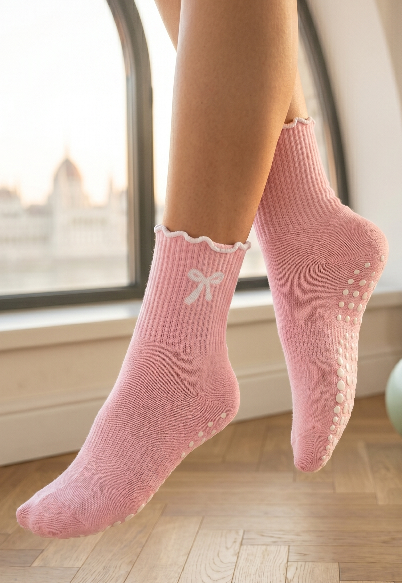 różowe skarpetki do pilatesu z kokardą na stopach modelki